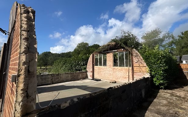 Completed asbestos cement roof removal from a derelict outbuilding in Woking, Surrey, with roof sheets fully cleared by Surrey Environmental Services