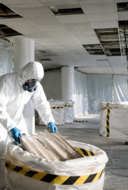 UKATA-trained operatives in full PPE removing asbestos ceiling tiles from a commercial property in Surrey with full containment controls in place