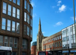 A view of a local Surrey town street showing residential and commercial property stock, reflecting the regional coverage area of our local asbestos team.