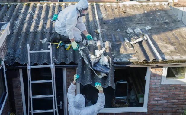 BOHS-trained asbestos surveyor inspecting a residential property ceiling in Surrey